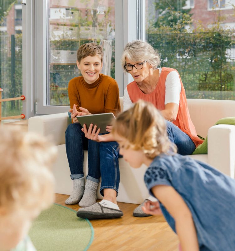 pre-school-teachers-with-tablet-looking-at-children-in-kindergarten.jpg